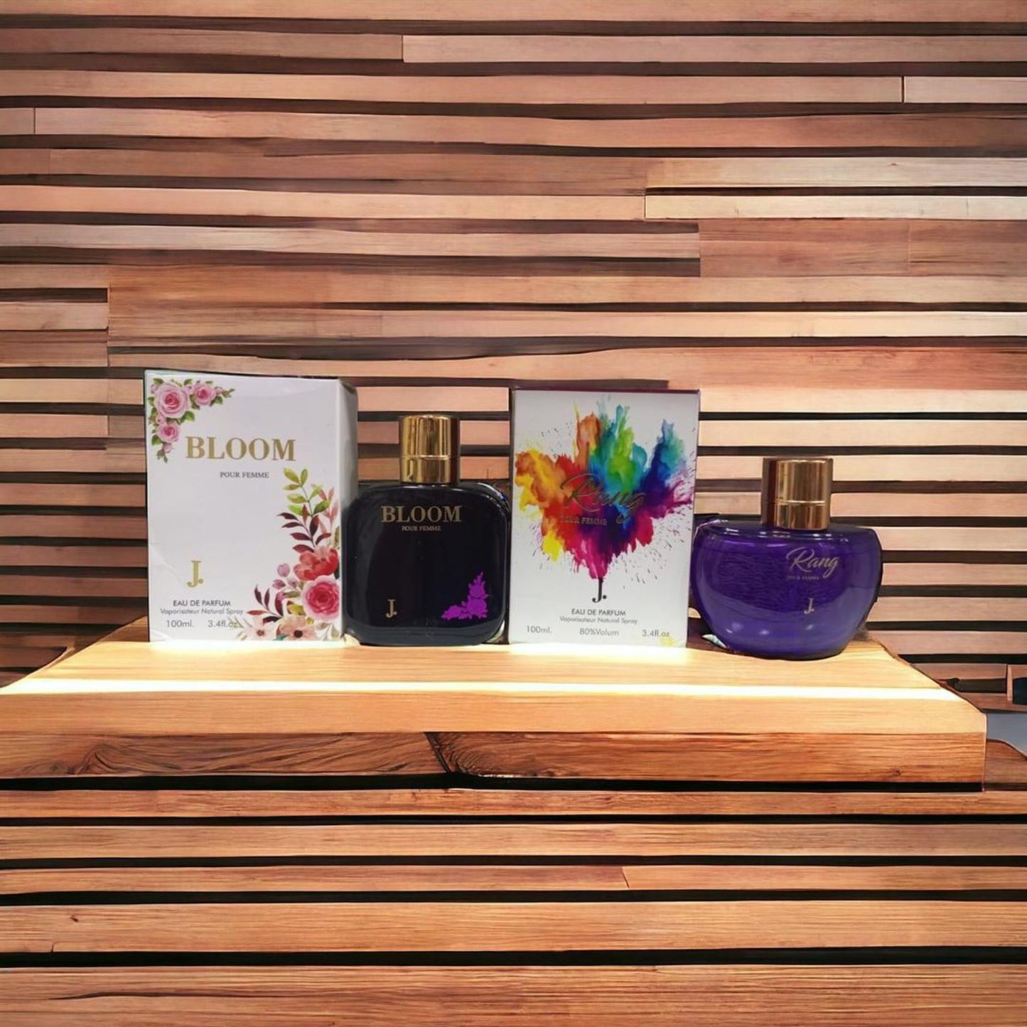 Two perfume bottles and their boxes on a wooden surface with a wooden slatted background