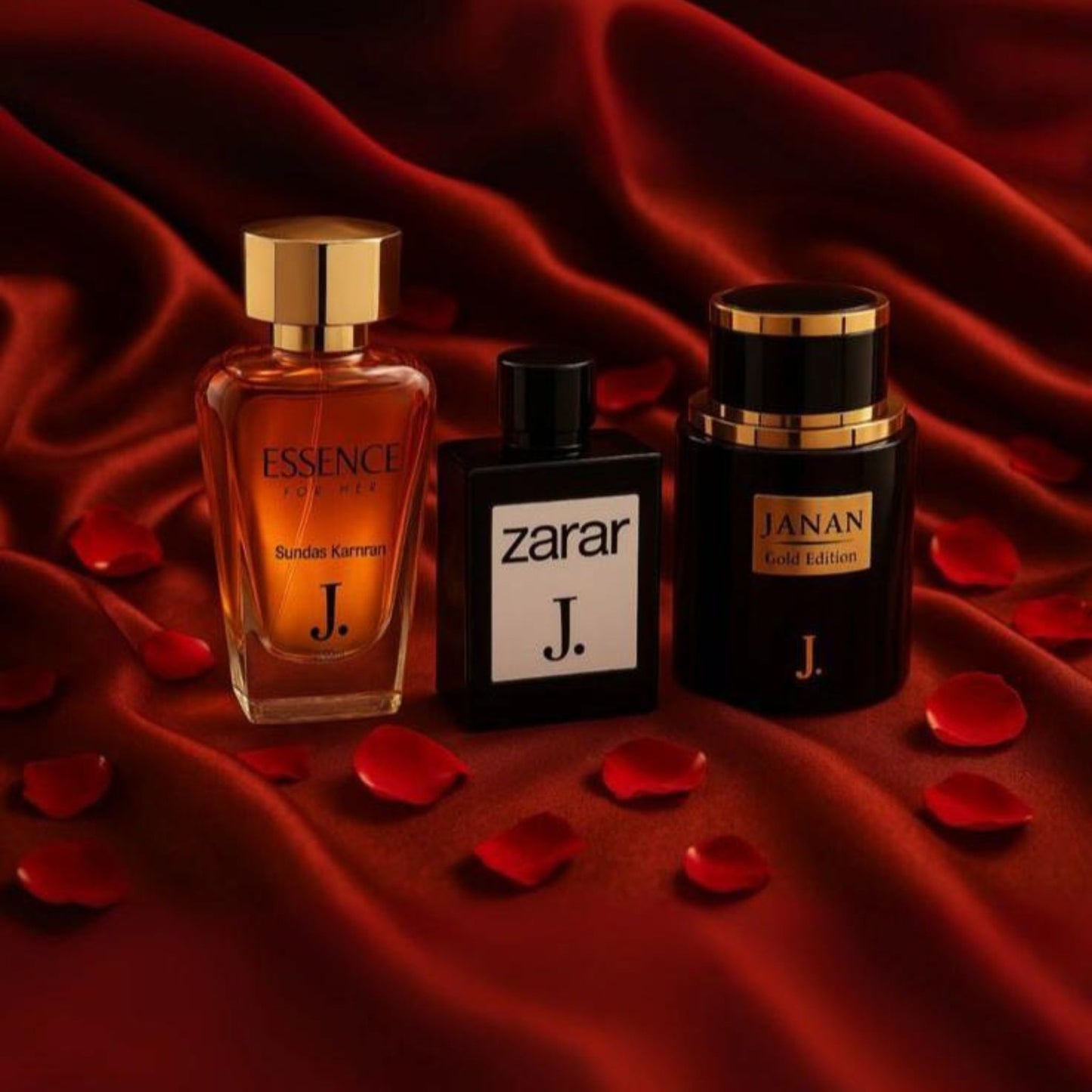 Three perfume bottles labeled 'Essence', 'Zarar', and 'Janan' on a red fabric background with rose petals.