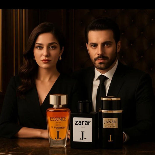 Two people standing behind three perfume bottles labeled 'Essence', 'Zarar', and 'Janan' on a wooden surface.