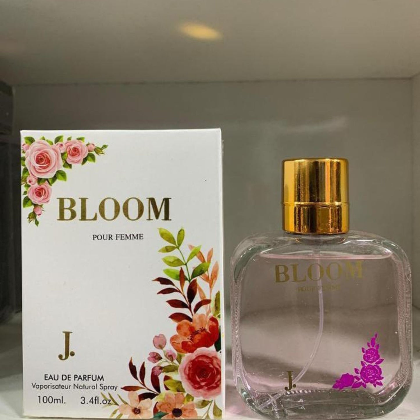 Bloom perfume bottle and packaging with floral design on a neutral background